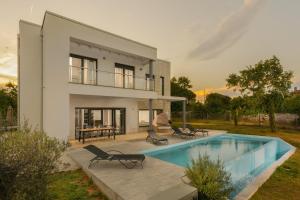 ein Haus mit einem Pool vor einem Haus in der Unterkunft Villa Monte D'Or in Krnica