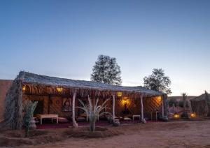 a hut in the desert with lights on it at Ali & Sara's Desert Palace in Merzouga