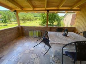 a patio with a table and chairs on a porch at Illésék Portája in Mindszentkálla