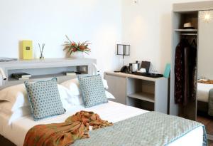 a bedroom with a bed with blue pillows and a desk at Sublimis Boutique Hotel Adults-Only in Camogli