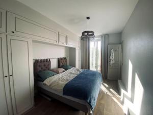een slaapkamer met een groot bed met blauwe lakens bij Spacieux appartement à 50m du Sacre Coeur - Magnifique Vue in Parijs