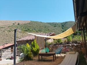 un patio trasero con hamaca, mesa y tobogán en El Rincon De Zaldierna en Zaldierna