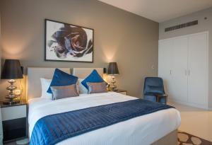 a bedroom with a large bed and a blue chair at Premium Studio with Beautiful Golf Course View in Dubai