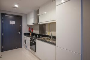 a kitchen with a sink and a stove top oven at Premium Studio with Beautiful Golf Course View in Dubai
