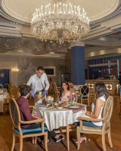a group of people sitting around a table in a restaurant at Al Masa Hotel Nasr City in Cairo