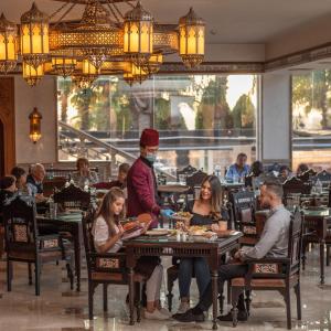 a group of people sitting at tables in a restaurant at Al Masa Hotel Nasr City in Cairo