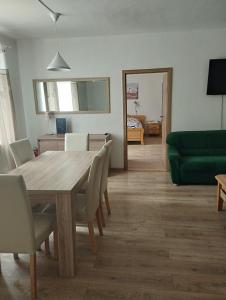 uma sala de estar com uma mesa de madeira e um sofá verde em Hostinec pod úbočou em Valaská