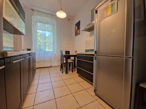 a kitchen with a stainless steel refrigerator and a table at Apartament Nadmorski in Ustronie Morskie