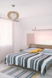 1 dormitorio con 1 cama con manta a rayas en MacskaFészek Vendégház, en Kissomlyó