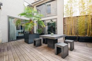 un patio avec une table et des bancs sur une terrasse dans l'établissement Edgar Suites - Bordeaux Meriadeck, à Bordeaux