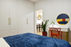 a bedroom with a bed and a table with a chair at Plac Unii - Barcelona 64 in Gdynia