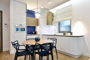 a kitchen and dining room with a table and chairs at Plac Unii - Barcelona 64 in Gdynia