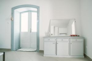 baño con espejo y lavabo blanco en MacskaFészek Vendégház, en Kissomlyó