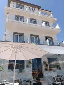 a large white building with a clock on it at Hotel Brienz in Bellaria-Igea Marina