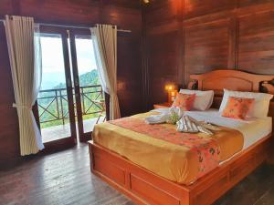 1 dormitorio con 1 cama grande y balcón en Munduk V View House, en Munduk