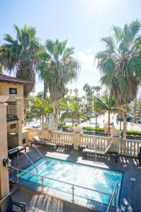 a swimming pool in a resort with palm trees at Balboa Inn, On The Beach At Newport in Newport Beach