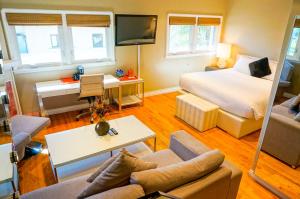 a hotel room with a bed and a living room at Balboa Inn, On The Beach At Newport in Newport Beach