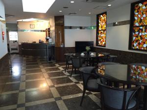 a restaurant with tables and chairs and stained glass windows at Urban Hotel Morishita in Tokyo