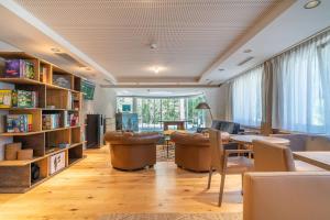 a living room with a table and chairs and bookshelves at Relais Lucomagno in Olivone