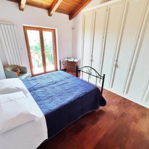 a bedroom with a bed with a blue comforter at Villa Di Gioia in Caccuri