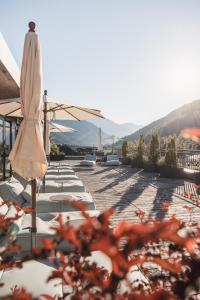 - une rangée de chaises et de parasols sur la terrasse dans l'établissement Anthony's Life&Style Hotel, à Sankt Anton am Arlberg