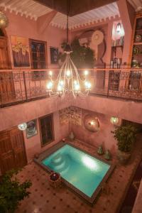 een binnenzwembad in een gebouw met een kroonluchter bij Riad Zayane Atlas in Marrakesh