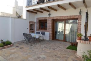 un patio con mesa y sillas. en Casa Rural La Madroña, en Fuenlabrada de los Montes