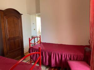 Habitación pequeña con cama roja y ventana en Casa Ela, en Serra San Bruno