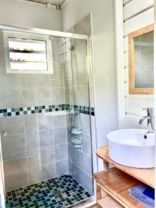a bathroom with a shower and a sink at Le Surf Lodge, chambre avec vue mer dans un écrin de verdure in Deshaies