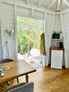 a living room with a table and a large window at Le Surf Lodge, chambre avec vue mer dans un écrin de verdure in Deshaies