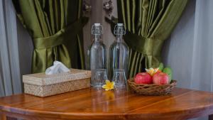 uma mesa com duas garrafas e maçãs e um cesto de flores em Odiyana Bali Retreat em Banyuwedang