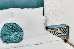 a green pillow sitting on top of a bed at ARI BLUE Apart în complexul Ared Kaufland in Arad