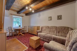 a living room with a couch and a table at Chalupa RAMZOVKA in Ramzová