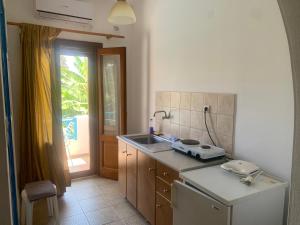 a small kitchen with a sink and a stove at Anixi in Astypalaia Town