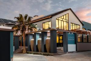a house with large windows and a palm tree at Swakopmund Sands in Swakopmund