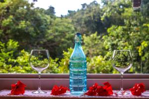 una botella de agua sentada junto a dos copas de vino en Pipa Surf Yoga en Pipa