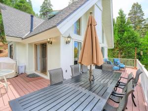 un patio con sombrilla y sillas en una terraza en Love It Up Here! at Lake Arrowhead Lakeview 5 bedrooms 2 lofts 4 decks, en Lake Arrowhead