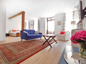 a living room with a blue chair and a table at Studio - Pied à Terre Saulieu in Saulieu