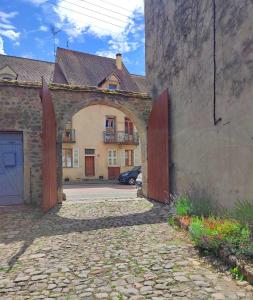 una entrada a un edificio antiguo con un arco en Pied à Terre Saulieu en Saulieu