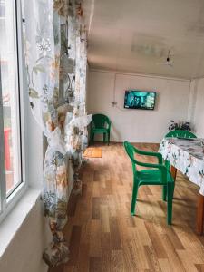 um quarto com uma mesa e cadeiras e uma cortina em Roshel em Bosteri