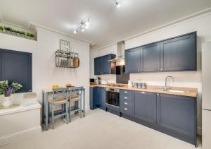 a kitchen with dark blue cabinets and a counter at Ellerby Lane House in Whitby