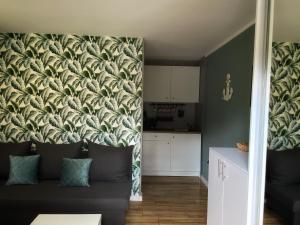 a living room with a couch and a wall mural at Aparth Plus 03 Okuninka in Okuninka