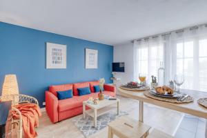 salon z czerwoną kanapą i niebieską ścianą w obiekcie Le bleu, très bien situé 1mn centre commerciale, Disney PARKING GRATUIT w mieście Serris