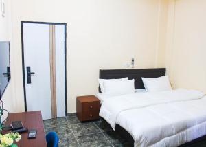 a hotel room with two beds and a table at High Level Apartment in Accra