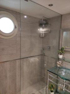 bagno con doccia in vetro e tavolo in vetro di B&B Michelangelo a Napoli