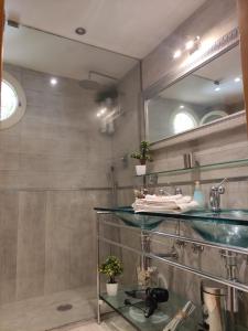 baño con estante de cristal y espejo en B&B Michelangelo en Nápoles