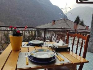 a wooden table with plates and utensils on it at Casa vacanza IL CORBETTO di Michela & Matteo in Locana