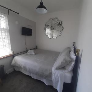 a bedroom with a bed and a clock on the wall at Coastguard Cottage Newquay in Newquay