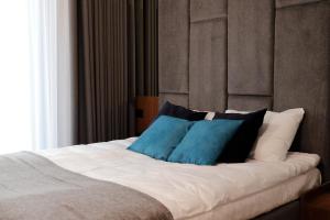 - un lit avec des oreillers bleus et noirs dans l'établissement Apartament Olimpijska 116, à Olsztyn