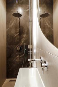 La salle de bains est pourvue d'un lavabo et d'un miroir. dans l'établissement Apartament Olimpijska 116, à Olsztyn